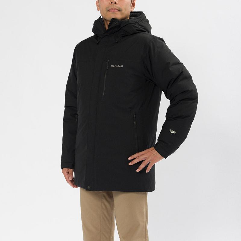 A man standing, facing forward, wearing a black Montbell down jacket with a hood, zippered pockets, and adjustable waist and cuffs.