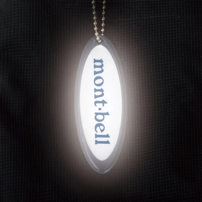 Montbell Safety Reflector Oval Logo in White, featuring a prismatic high-brightness finish and attachment chain.