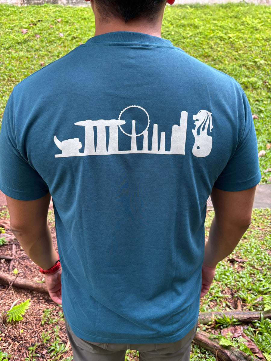 blue-green Montbell Singapore Icon Wickron T-shirt with white Singapore skyline graphic on the back.