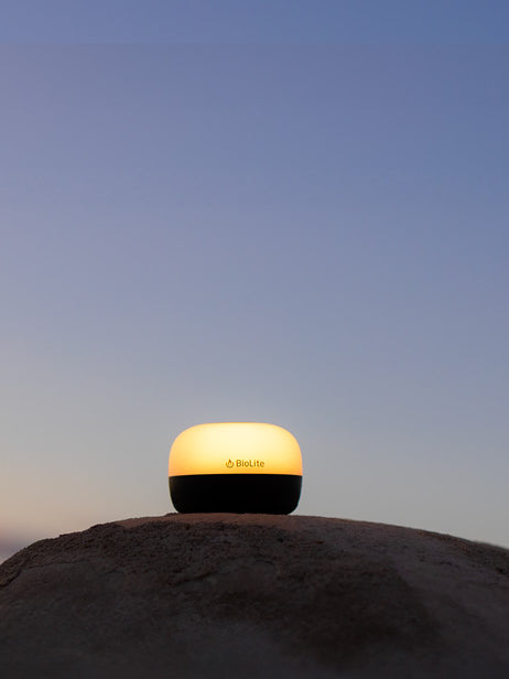 BioLite AlpenGlow Mini lantern glowing on a rock at dusk