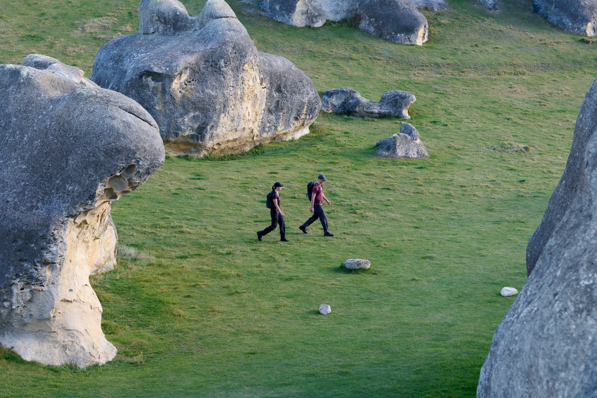 Two hikers in icebreaker merino crossing a boulder field