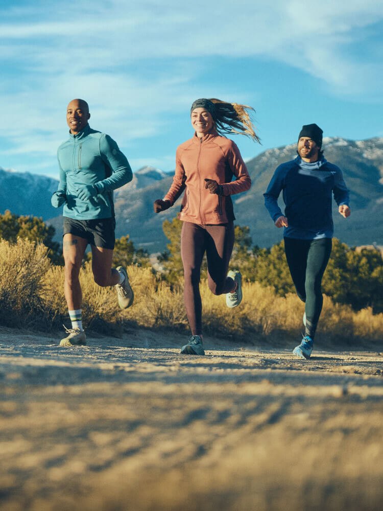 Three runners on a mountain trail in Smartwool merino layers