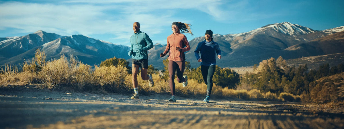 Three runners on a mountain trail in Smartwool merino layers